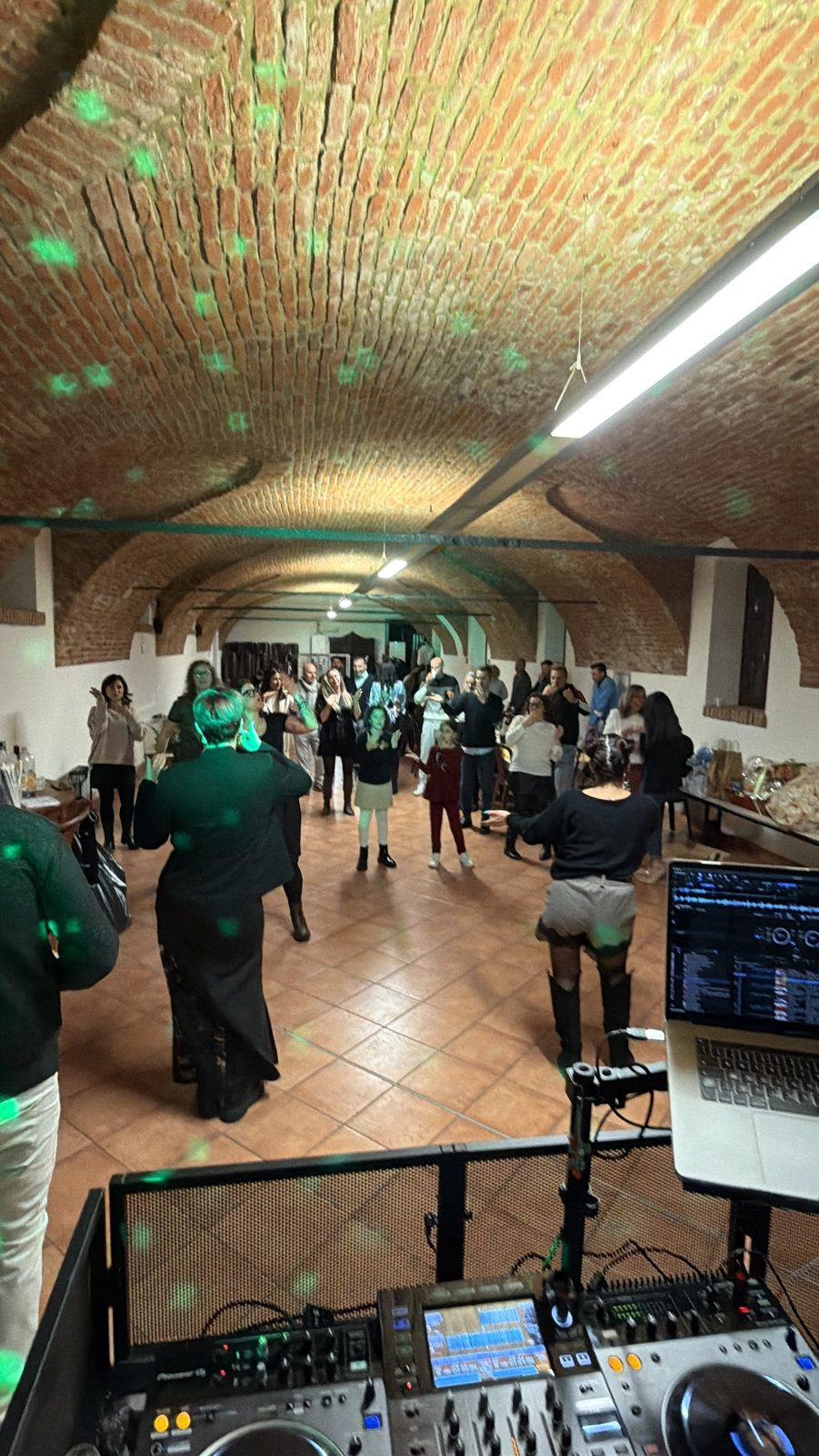 Festa in una sala con volta in mattoni e luci verdi